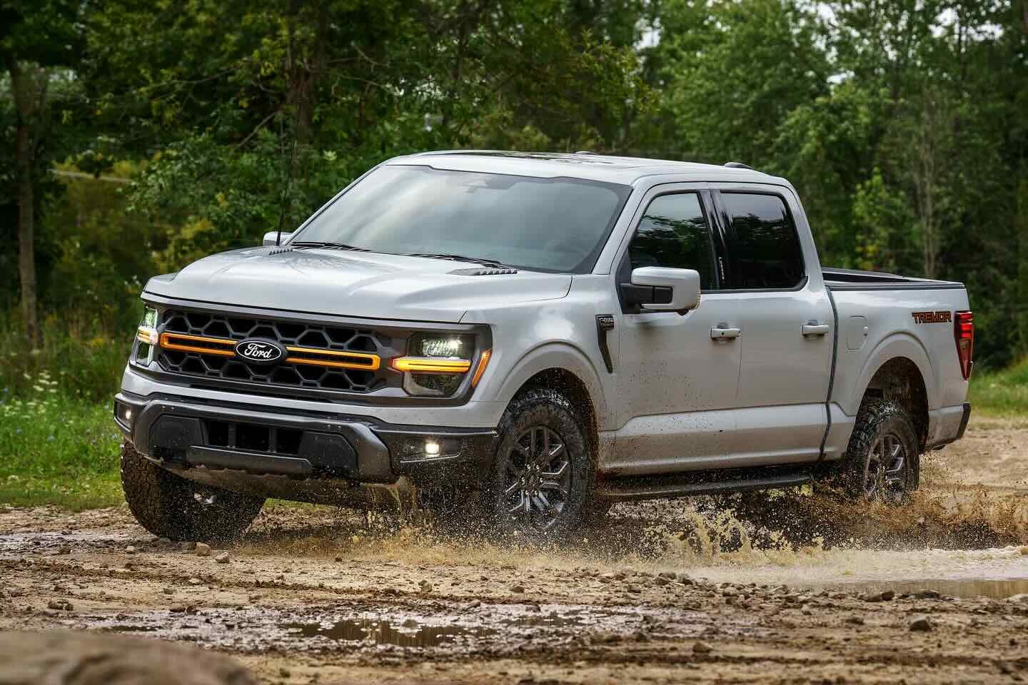 Used Ford F-150 Tremor splashing through mud on an off-road trail