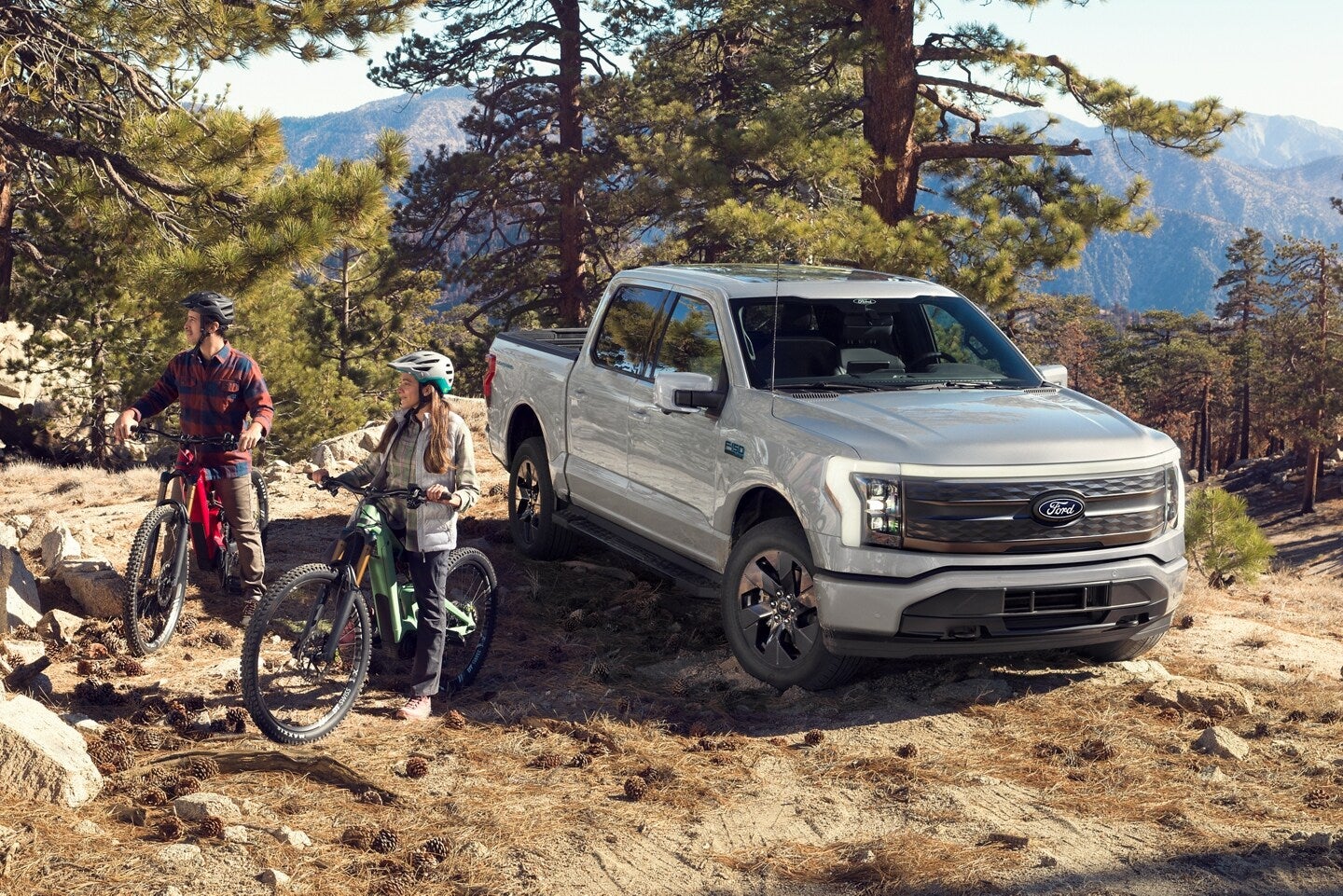 Family with mountain bikes next to a used Ford F-150 in the mountains