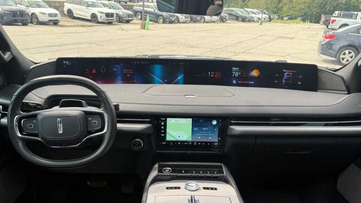Dashboard of a used 2025 Lincoln Navigator Reserve with its 48-inch panoramic display lit, on the lot at Dennis Sneed Ford in Gower, Missouri