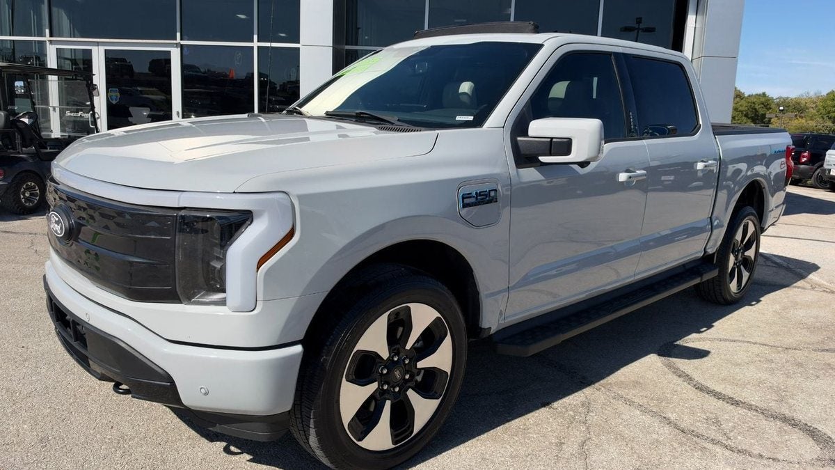 Silver 2024 Ford F-150 Lightning Platinum outside the Ford showroom at Dennis Sneed Ford in Gower, Missouri