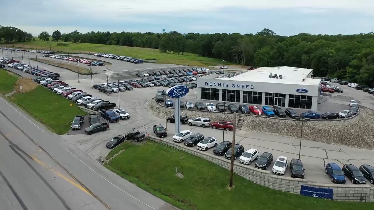 Aerial view of Dennis Sneed Ford in Gower, Missouri, showing the showroom, Ford sign, and truck inventory along US-169 north of Kansas City