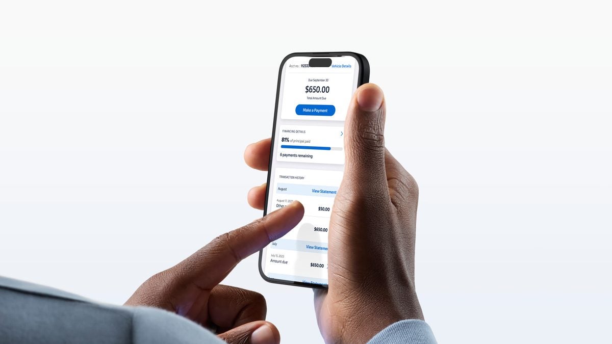 Hands holding a smartphone showing an auto loan account in the Ford Credit app, with a $650 payment due and 81% of the principal paid